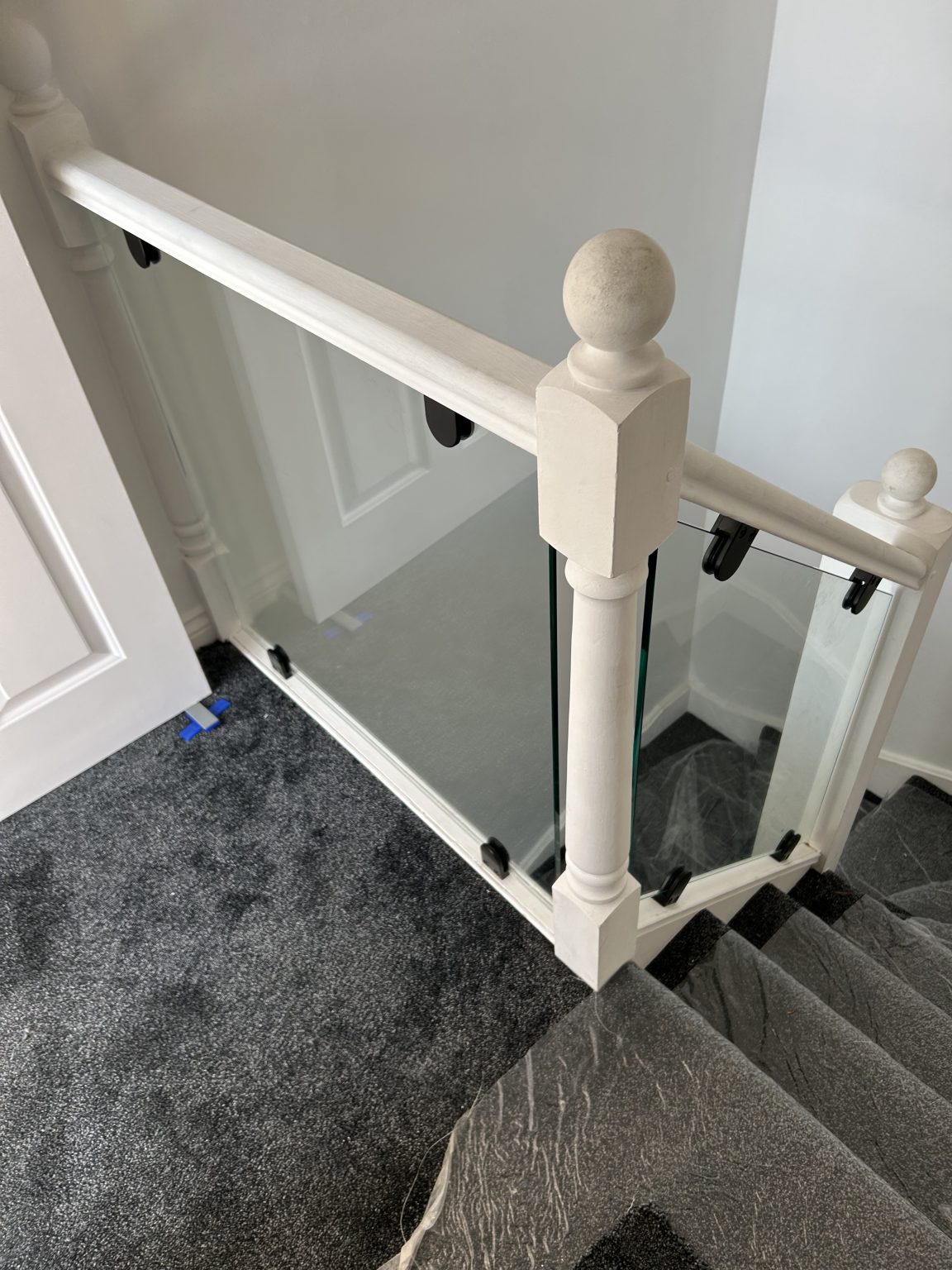 Glass balustrade with oak handrail fitted on a staircase by Andrews Glass in Hertfordshire